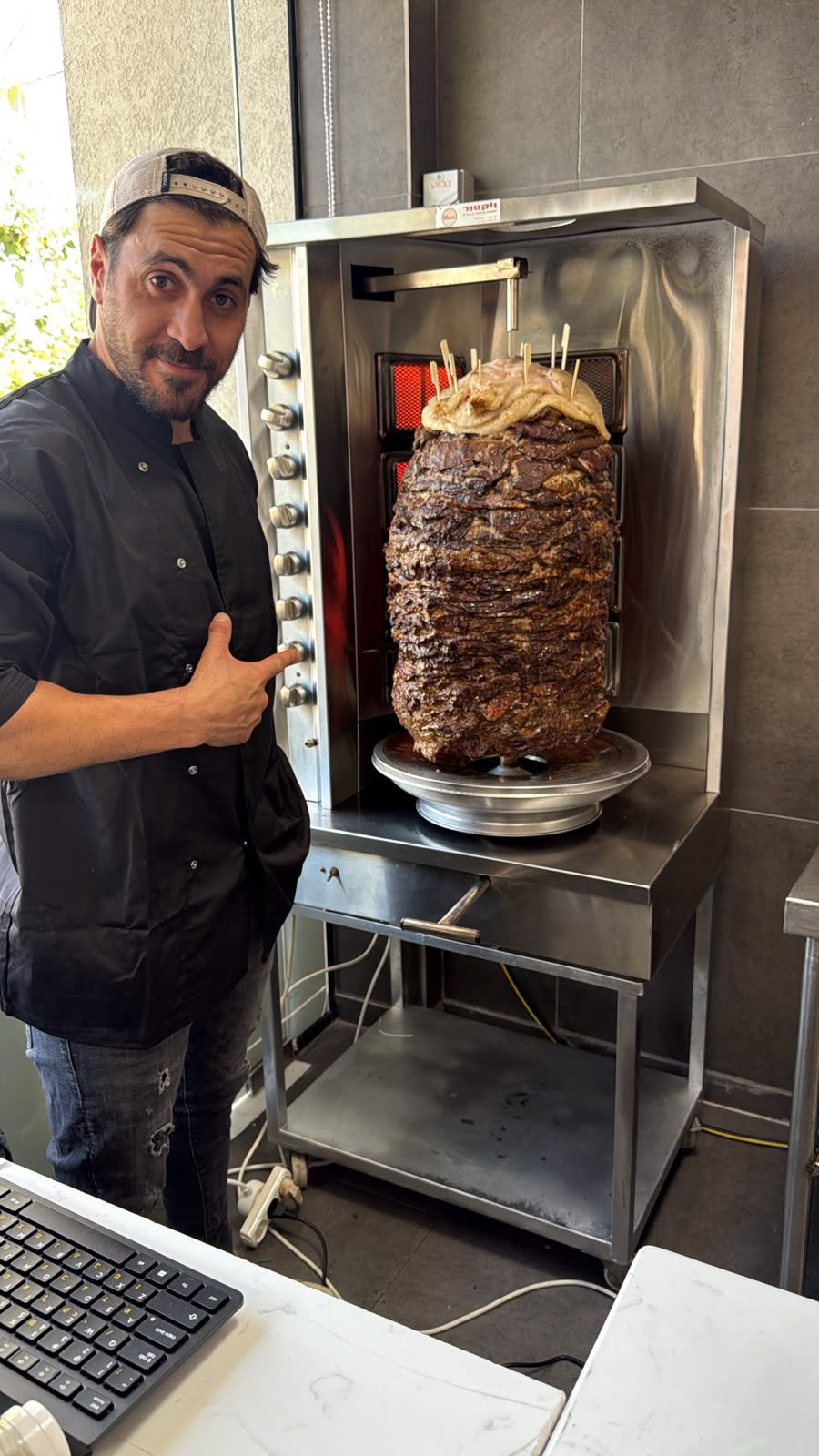 Shawarma House chef beside the shawarma spit